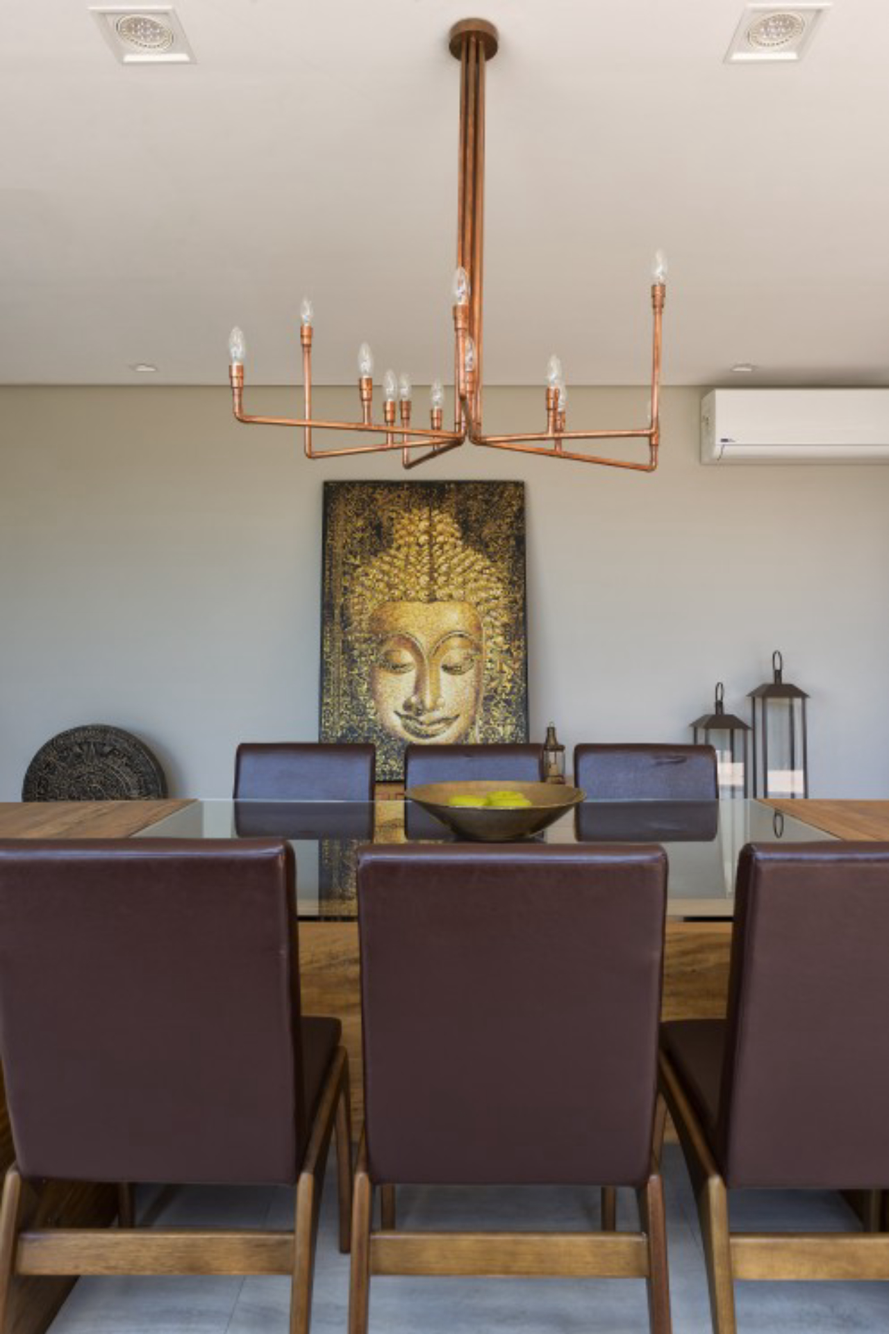 O grande quadro de buda é destacado pelo pendente em tom de cobre.