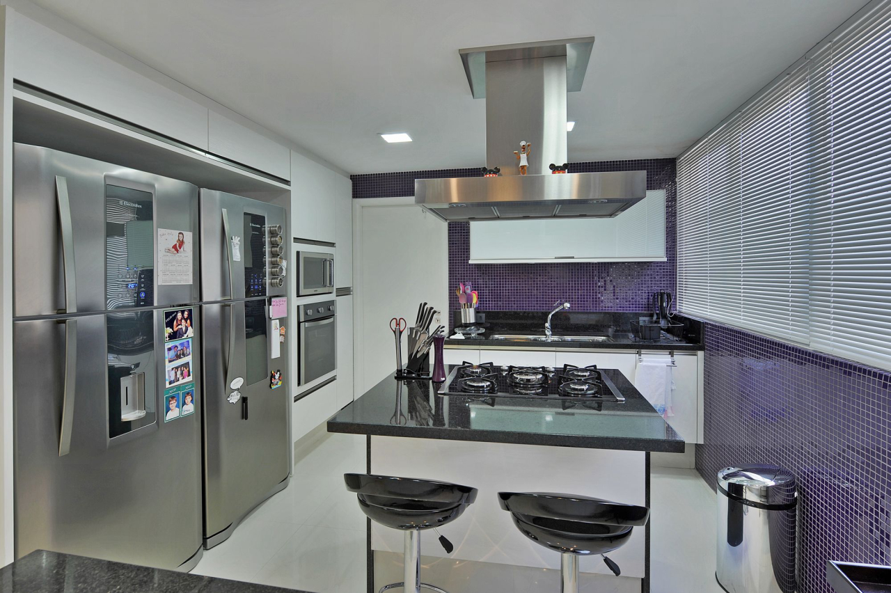 Para a cozinha os arquitetos abusaram da cor roxa nas pastilhas, e da linha de eletrodomésticos em aço inox.