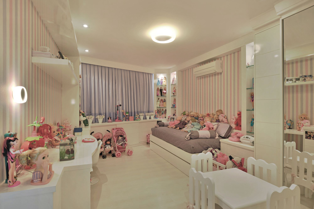 O quarto da menina traz diversos tons de rosa e lilás. O mobiliário projetado facilitou o aproveitamento de todo o espaço disponível e a escolha pelas peças funcionais permite que a criança utilize em diversas fases da vida.