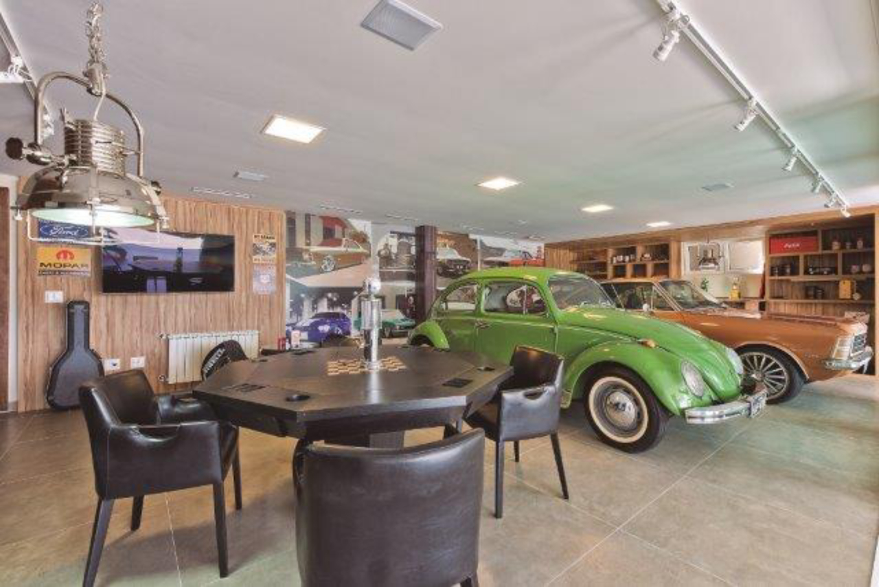 A garagem é temática, com decoração retrô. O dono também possui uma coleção de carros antigos, que complementam ainda mais o ambiente.