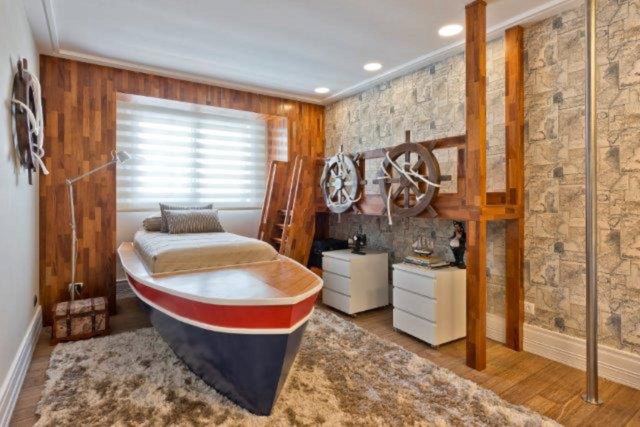 O quarto foi projetado para um menino de nove anos. O papel de parede tem tema de caça ao tesouro e a cama foi modelada em formato de barco.