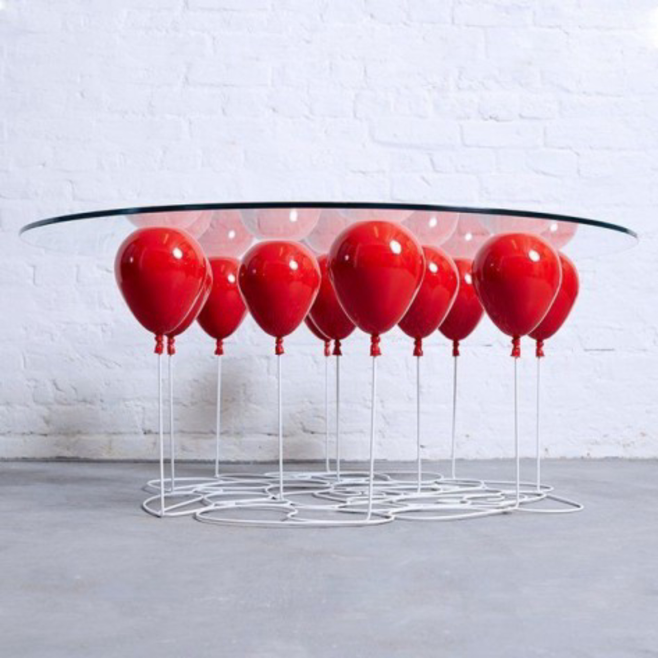 Uma mesa lúdica com suporte de balões de festa.