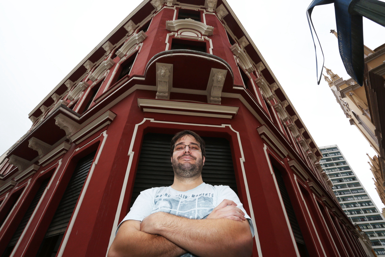 O arquiteto Leandro Nicoletti na fachada da Casa Hauer. Crédito: Ivonaldo Alexandre / Gazeta do Povo<br>