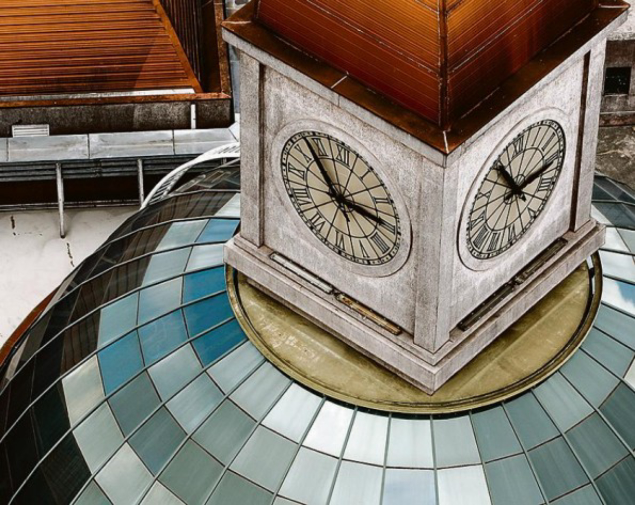 Releitura contemporânea das cúpulas clássicas no Shopping Estação: uma cúpula espelhada, sobreposta por um lanternim com  relógio, que, por sua vez, é coberta por uma cúpula menor.