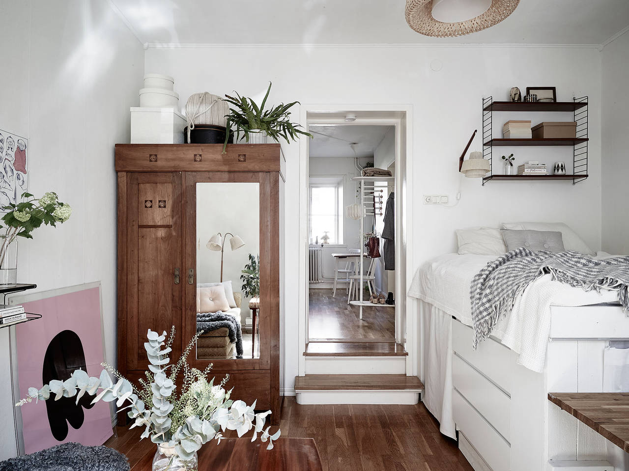 Um guarda-roupa com madeira semelhante ao piso o deixa praticamente invisível ao lado da porta. Dois degraus levam à cozinha, por onde se entra no apartamento. <p></p>