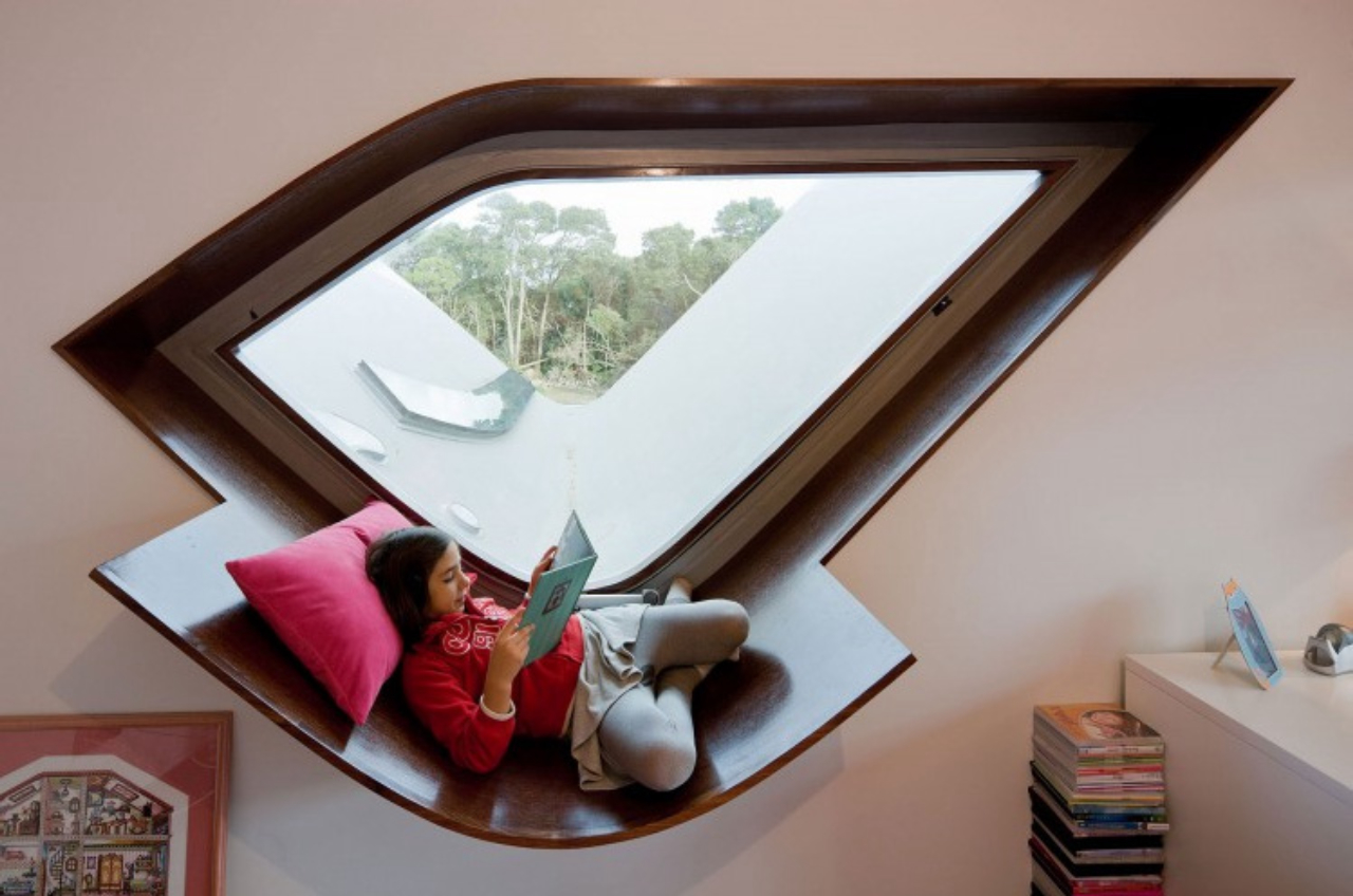 Uma folha da madeira que segue o desenho da janela foi a solução encontrada para ter um local para ler. Foto: Bernardo Rodrigues/ Divulgação