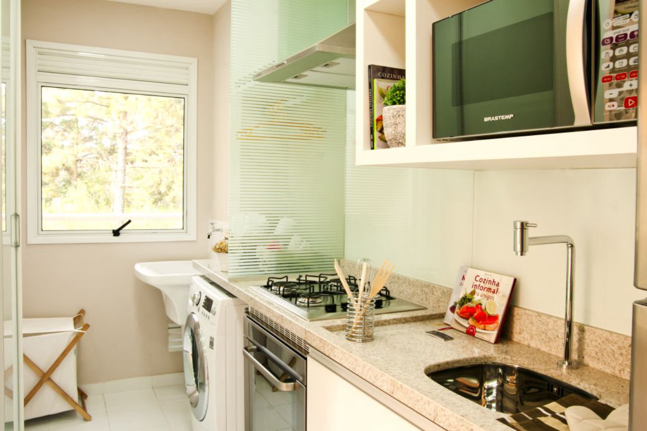 Helaine Góes aproveitou para integrar as bancadas da cozinha e lavanderia, delimitando os espaços com uma divisória em vidro.