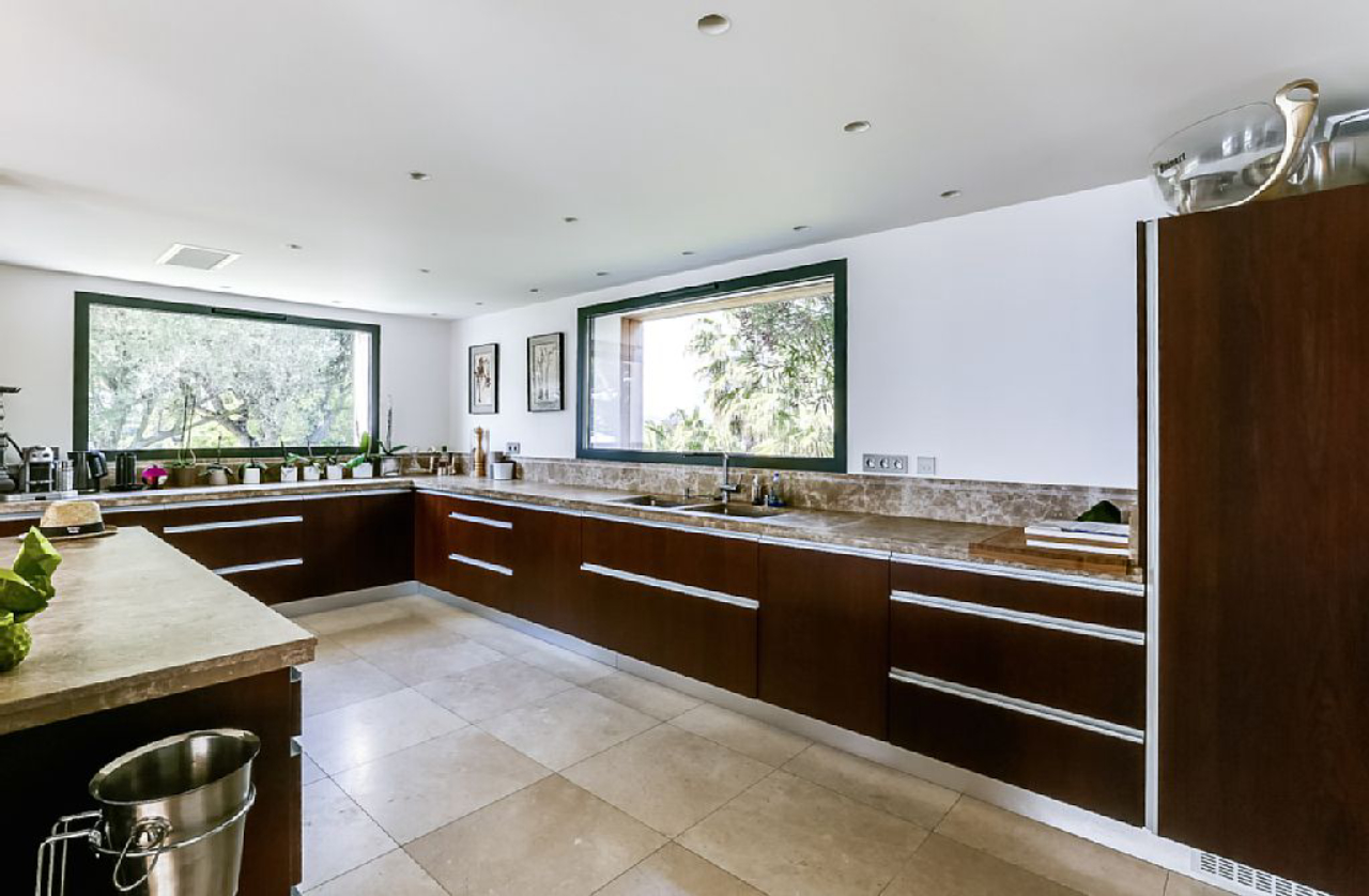 Cozinha da mansão com grandes janelas para integração com a área externa.<br>Foto: Airbnb / Divulgação