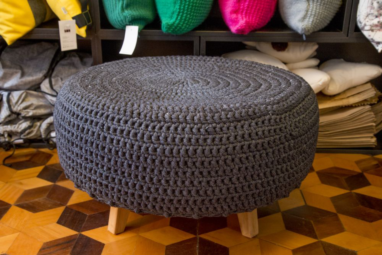 O pufe representa muito bem os valores da Casabau: é feito de pneu reaproveitado, com capa de crochê e pé de madeira. O item sai por R$ 400. Foto: Hugo Harada/Gazeta do Povo