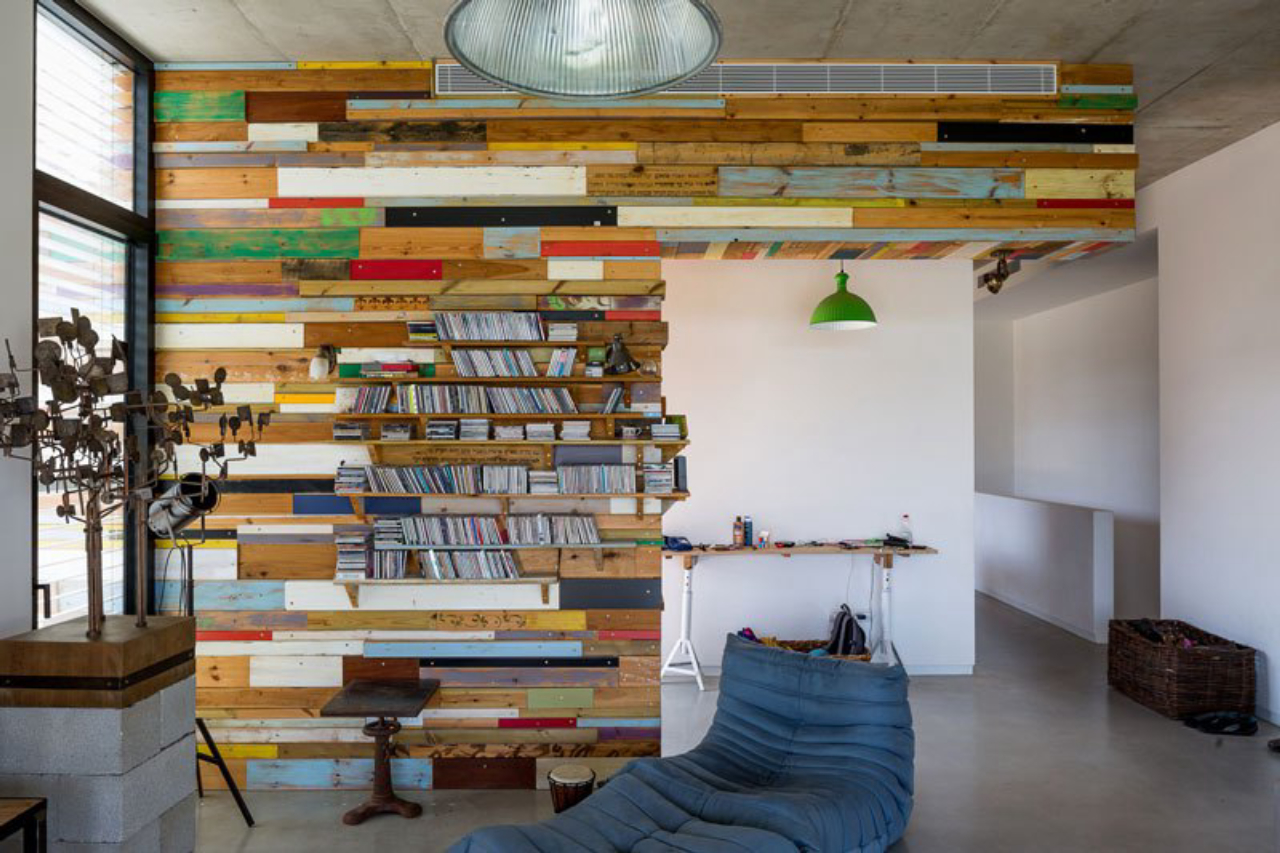 Espaço do escritório com a parede revestida em madeira colorida. 