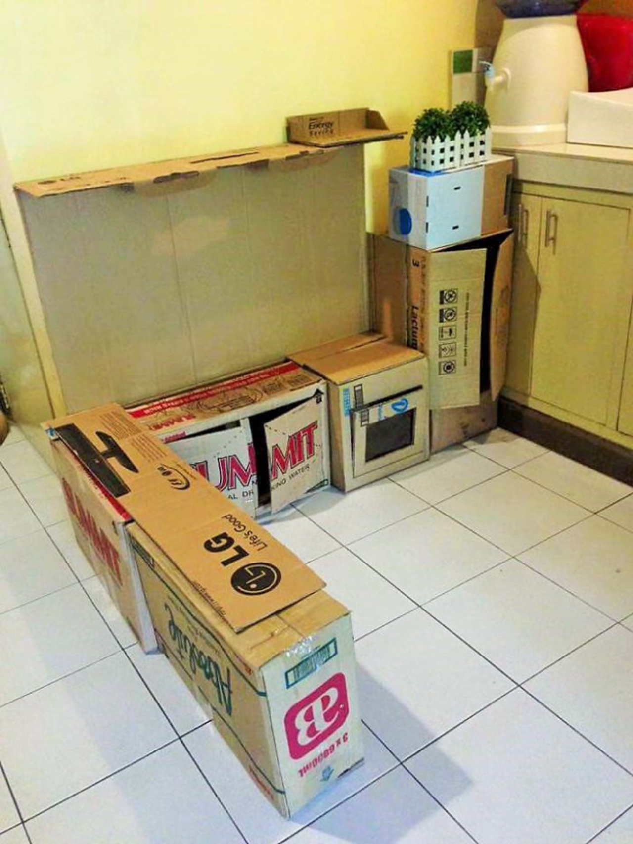 O primeiro passo foi alinhar as caixas de papelão já com os cortes de aberturas de armários, fogão e geladeira.<br>Foto: Reprodução