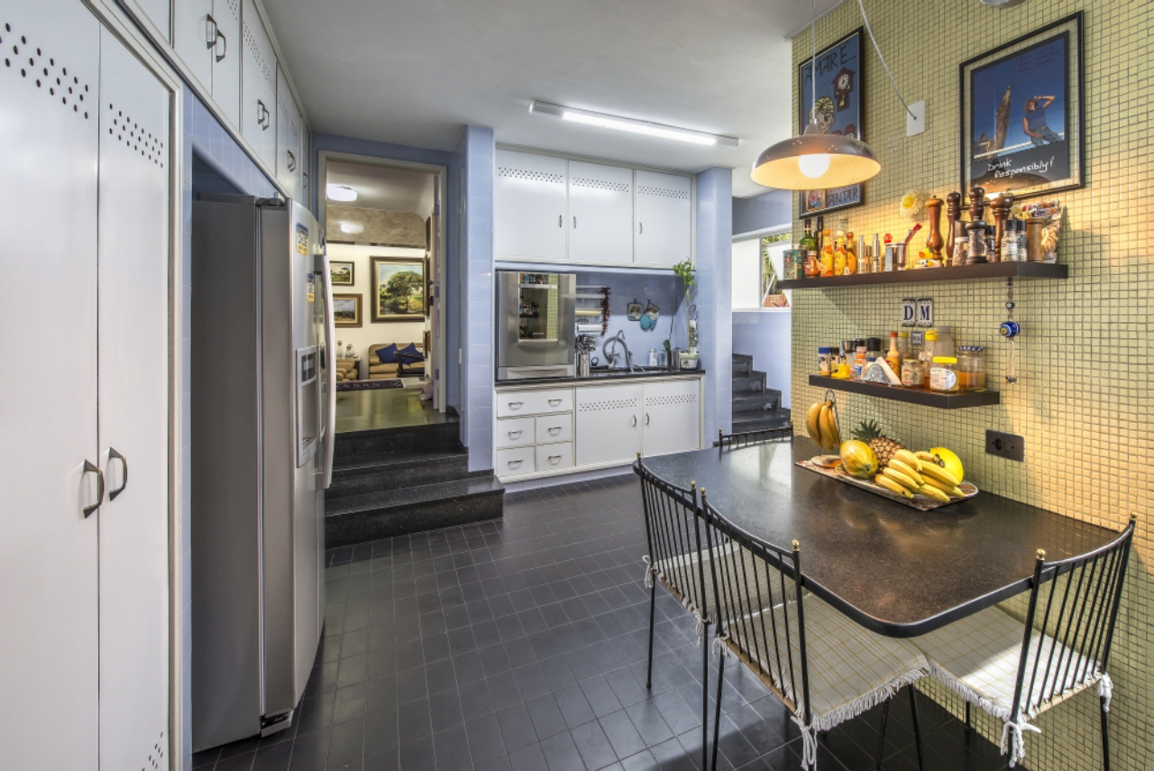 A cozinha possui móveis em concreto e revestidos de azulejo.