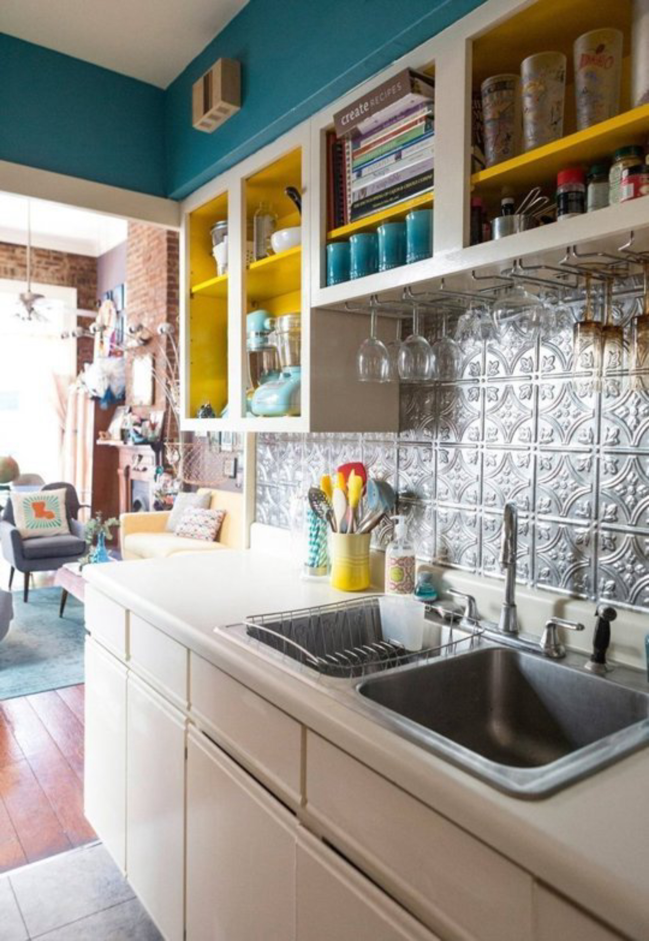 Cozinha descolada com os nichos amarelos em composição com a parede azul.<br>Foto: Reprodução Pinterest.  