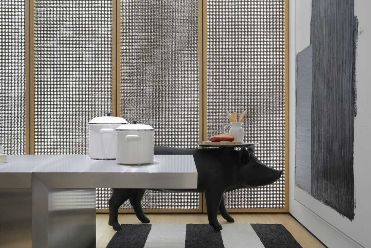 No projeto, mesa em aço inox substitui fogão, esquentando panelas por meio de cocção por indução (Divulgação/Studio Guilherme Torres)