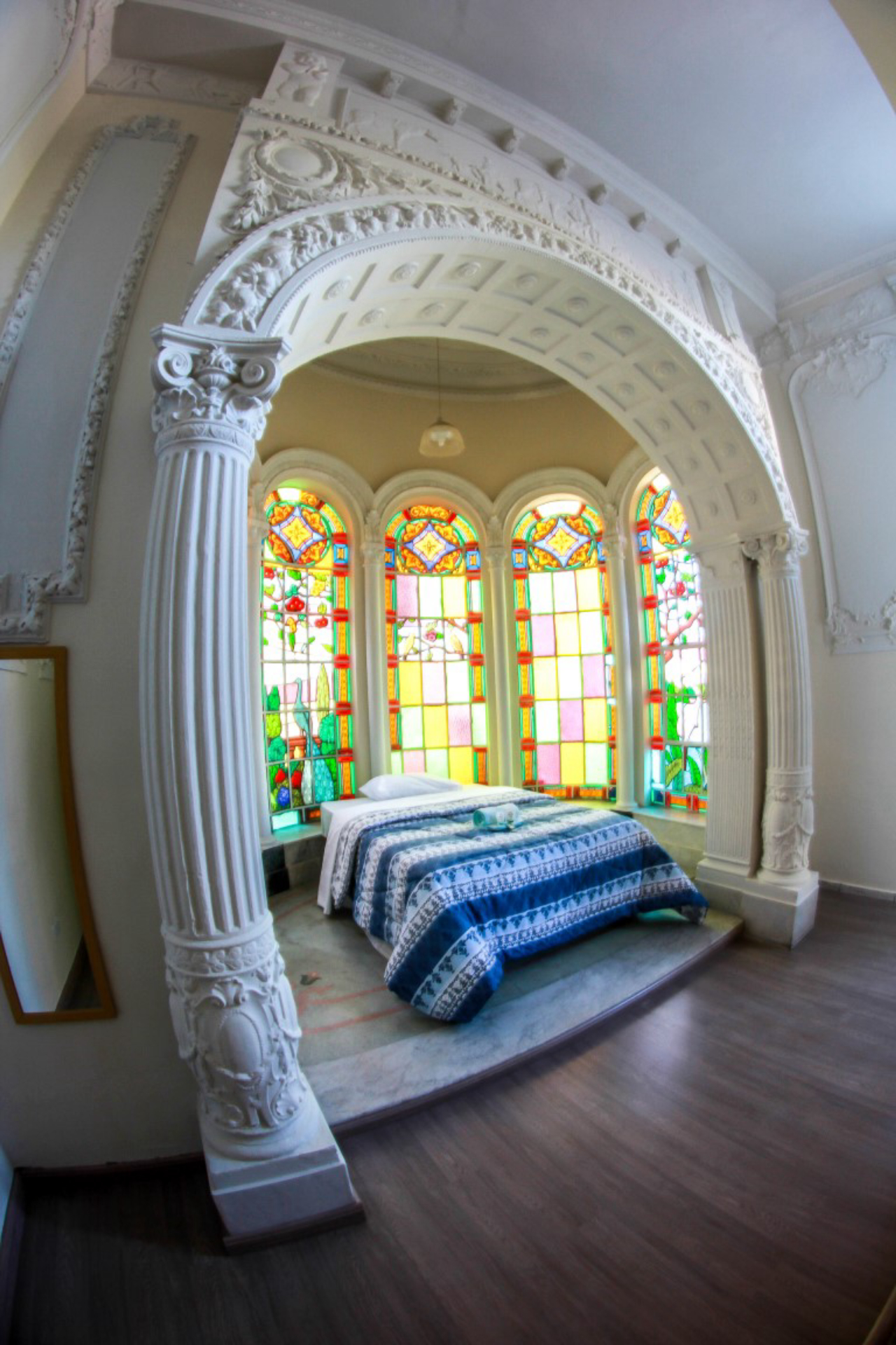 Colunas e vitrais fazem parte do cenário do quarto principal do hostel.