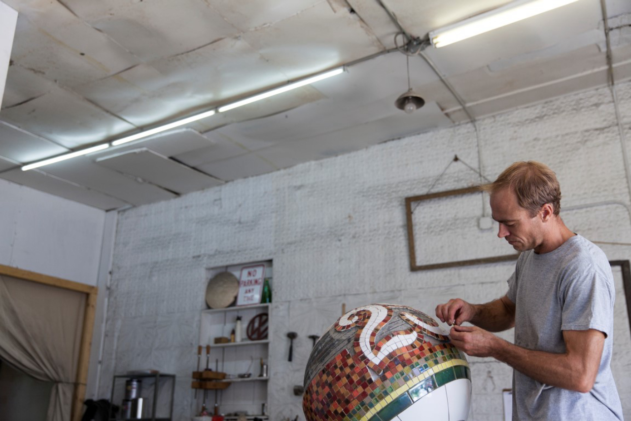 Artist Lars Fisk works on a "subway" ball, with tiling like that inside the city's 23rd Street Station, at his studio in New York, Aug. 17, 2016. Fisk, whose work is most often found outdoors, is exhibiting inside for a change, with a solo show called "Mr. Softee," opening Sept. 8 at the Marlborough Chelsea gallery. (Matthew Johnson/The New York Times)