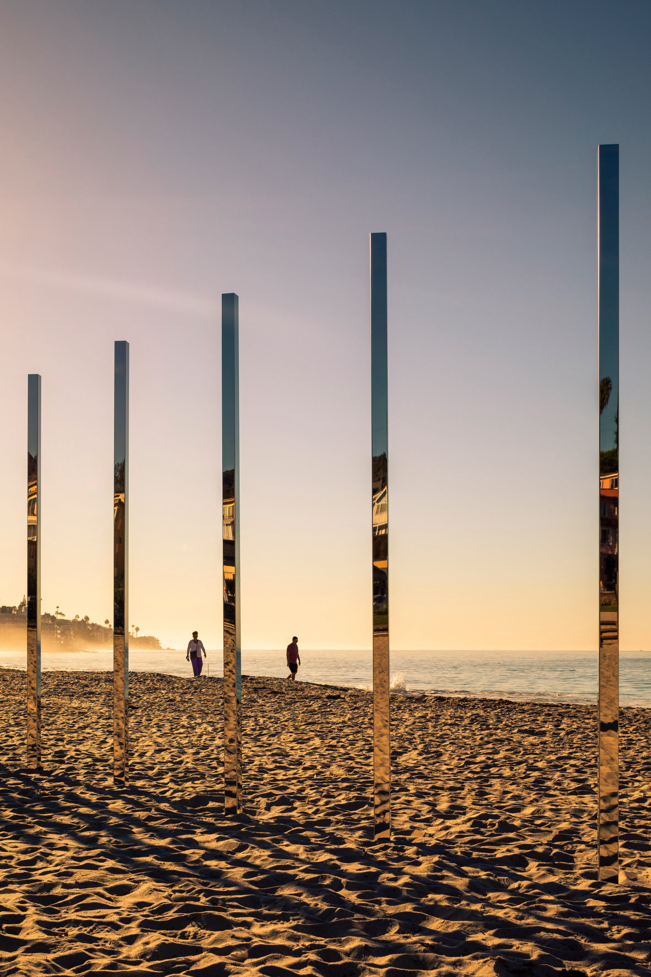 Postes alinhados em praia mudam impressão conforme ponto de vista
