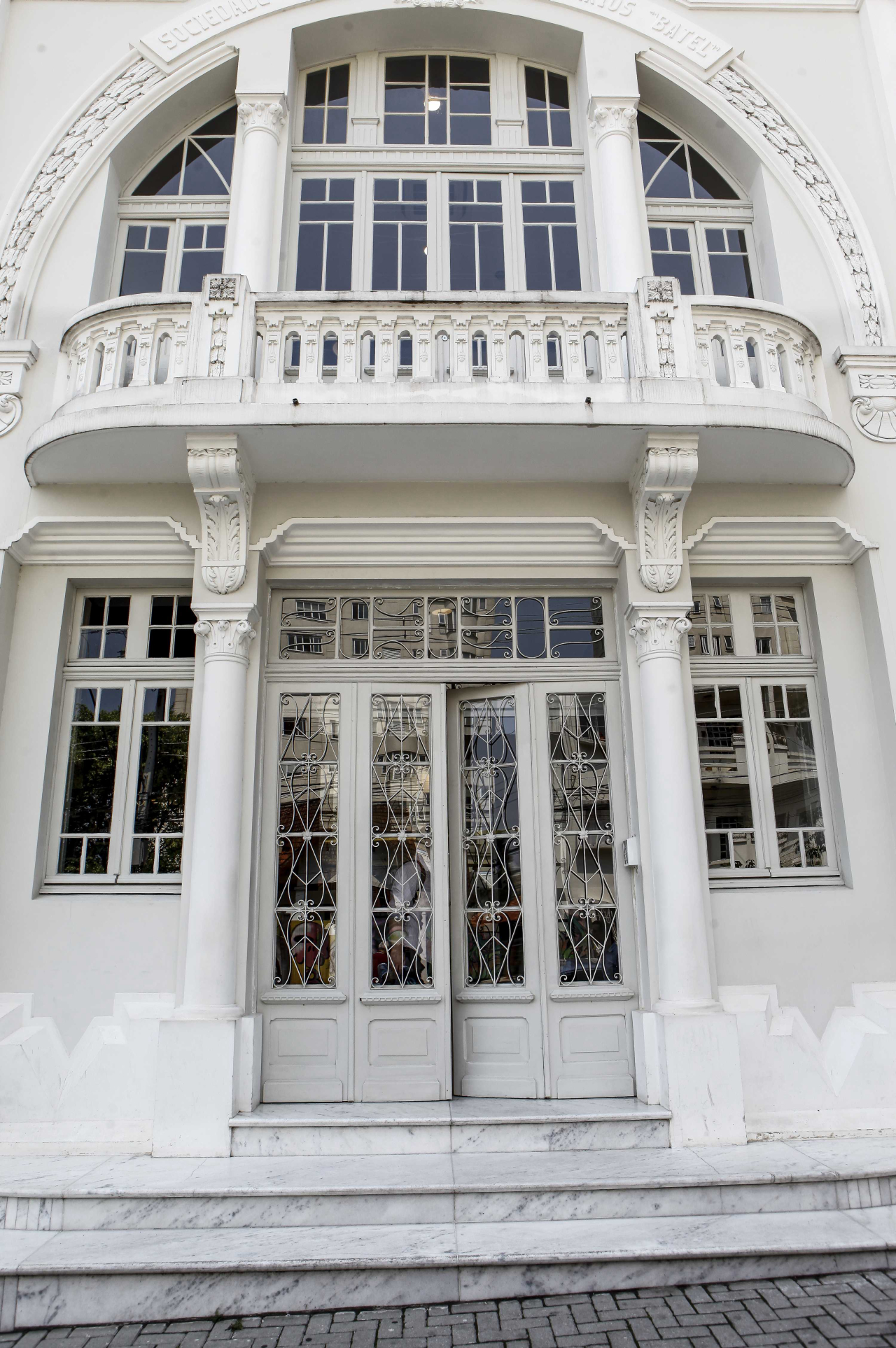 O histórico prédio da Sociedade Beneficiente dos Operários do Batel recebe as pessoas com uma porta majestosa