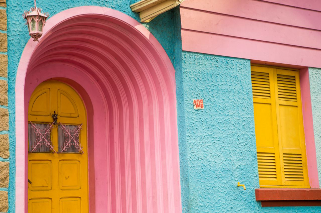 Os detalhes do colorido impressionam. Na imagem, a porta amarela faz contraste com a entrada, pintada de rosa, e com o restante da casa, em azul. Foto: Hugo Harada/Gazeta do Povo