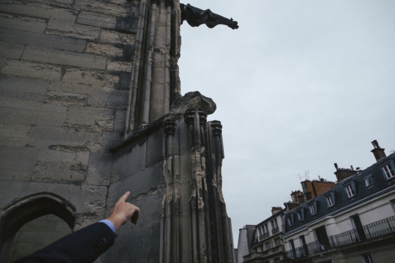 André Finot, spokesman of the Notre Dame Cathedral in Paris, points out eroded masonry on the structure, Sept. 19, 2017. Rain, wind and pollution have battered the cathedral, which is seeking funds in France and in the United States to help pay for extensive renovations. “Everywhere the stone is eroded, and the more the wind blows, the more all of these little pieces keep falling,” he said. (Dmitry Kostyukov/The New York Times)