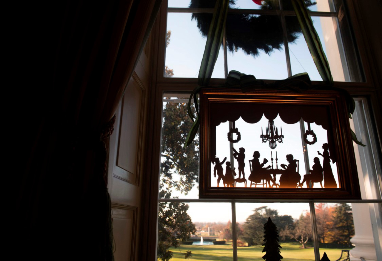 Christmas decorations are seen hanging in the window of the Green Room during a preview of holiday decorations at the White House in Washington, DC, November 27, 2017. / AFP PHOTO / SAUL LOEB
