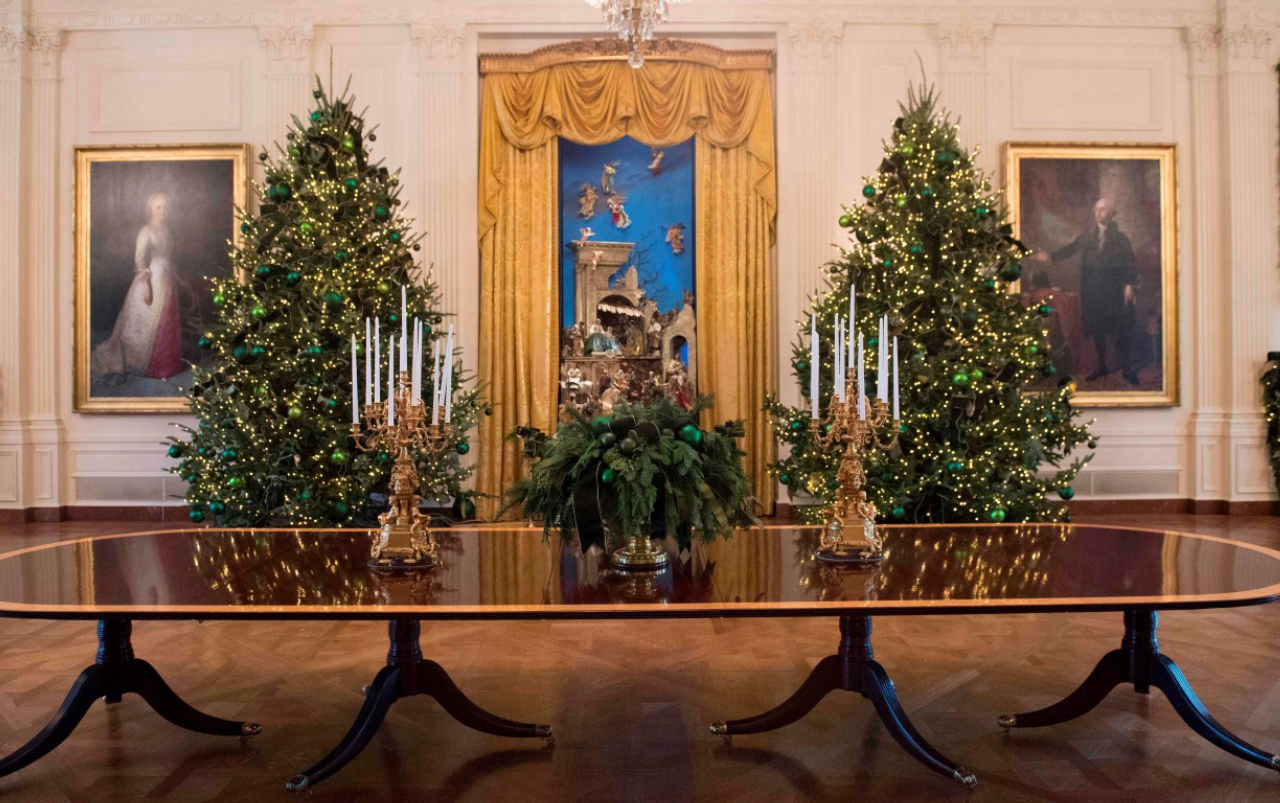 Christmas trees are seen during a preview of holiday decorations in the East Room of the White House in Washington, DC, November 27, 2017. / AFP PHOTO / SAUL LOEB