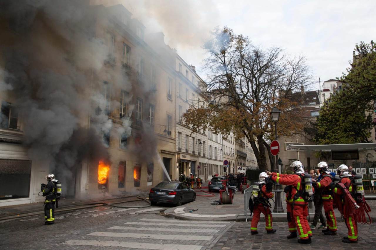 Firefighters work to put out a fire in "La Hune" book shop in Paris on November 16, 2017.<br>Seven people were lightly injured in the fire, and some 50 firefighters and a dozen vehicles were deployed. / AFP PHOTO / Karim DAHER