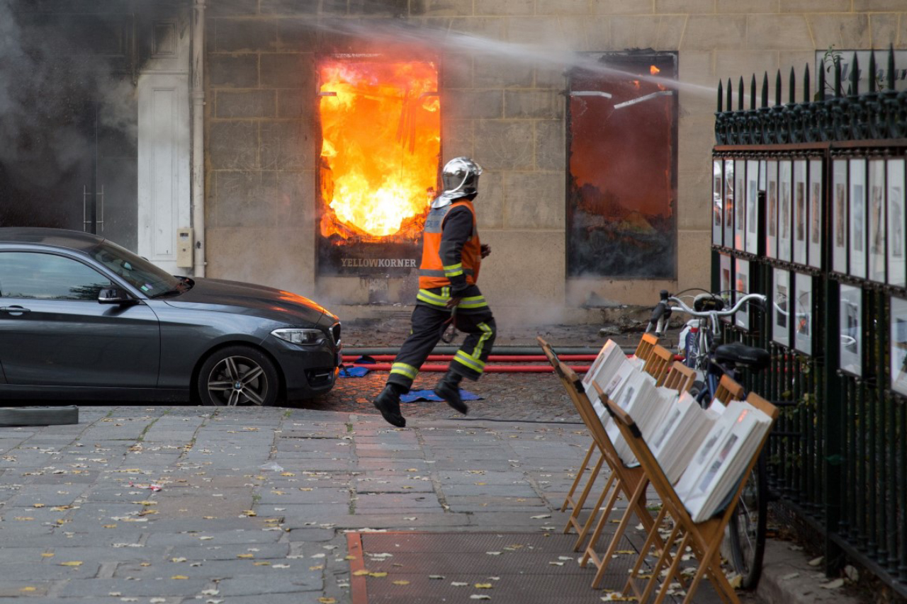 A firefighter runs as he works to put out a fire in "La Hune" book shop in the Saint-Germain-des-Pres district Paris on November 16, 2017.<br>Seven people were lightly injured in the fire, and some 50 firefighters and a dozen vehicles were deployed. / AFP PHOTO / Karim DAHER
