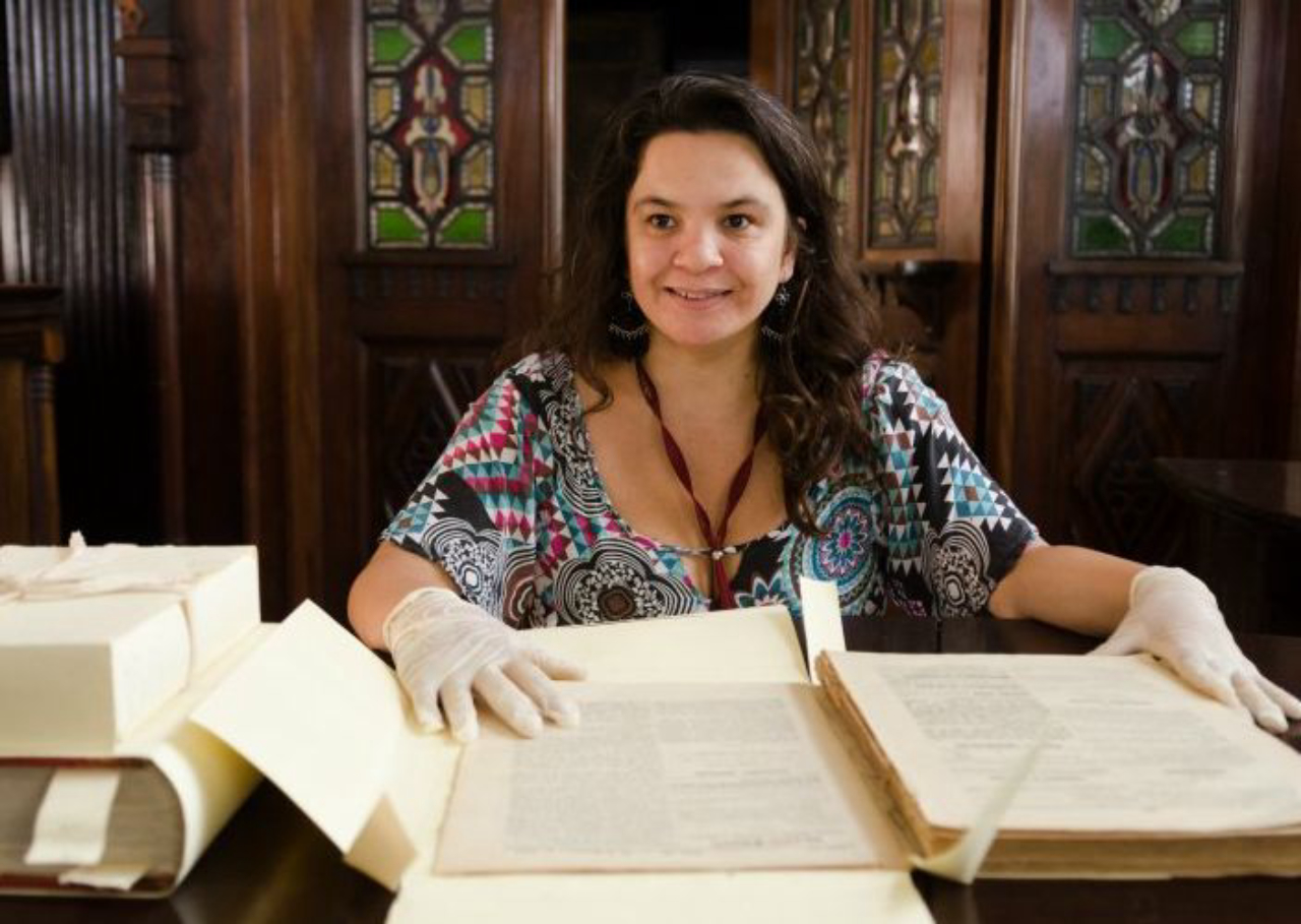 Responsável da Seção de Obras Raras da Fiocruz, Maria Cláudia Santiago, com o manuscrito. Foto: Raquel Portugal / Icict / Fiocruz