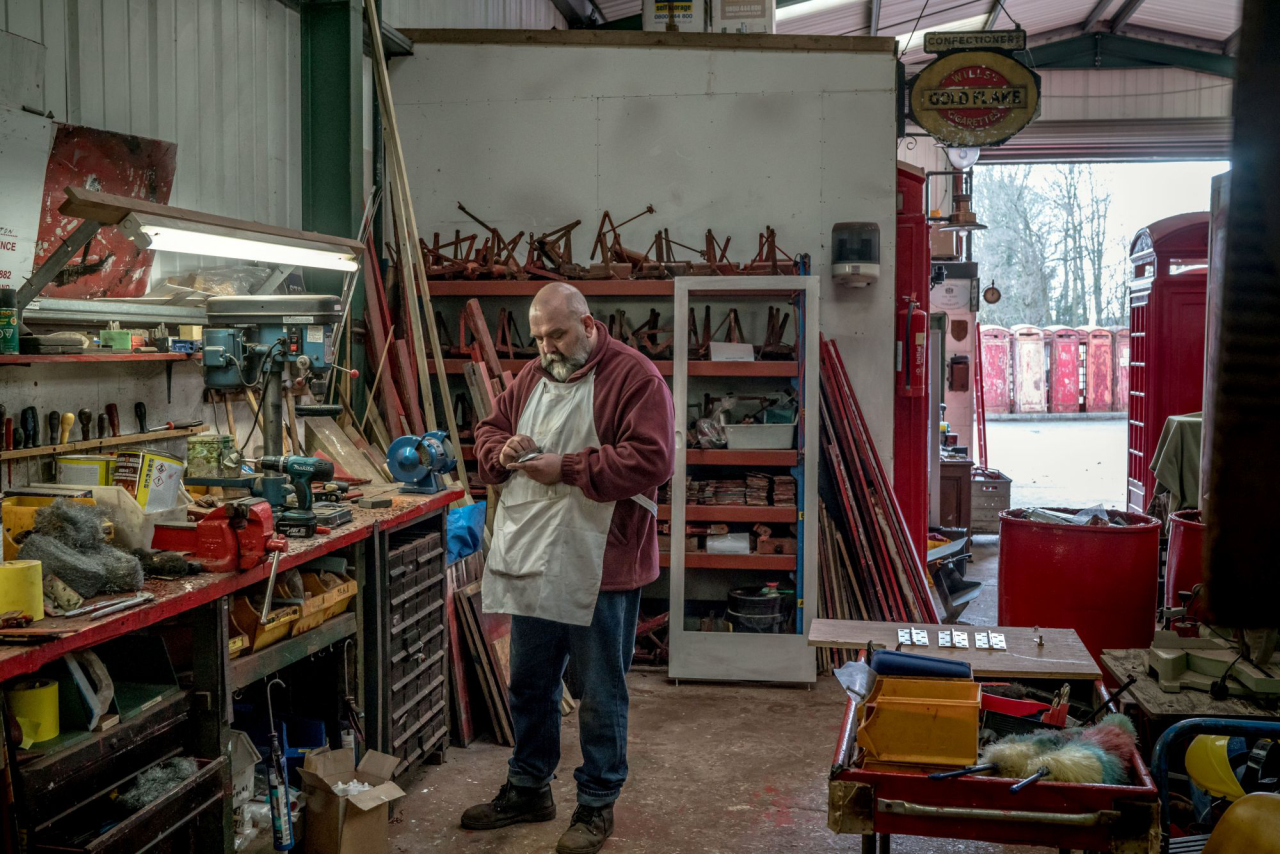 Tony Inglis em uma oficina onde ele restaura cabines telefônicas e outros móveis de rua na Inglaterra. (Foto: Andrew Testa/The New York Times)