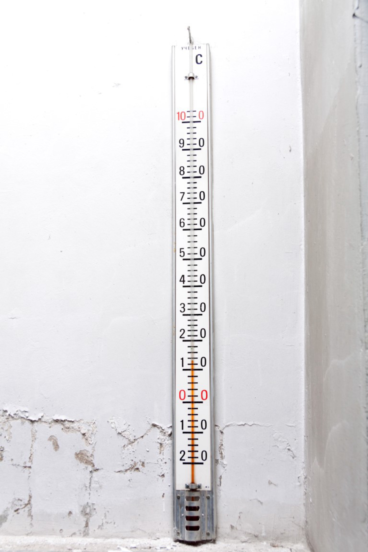 Old thermometer on an old wall, vertical shot.