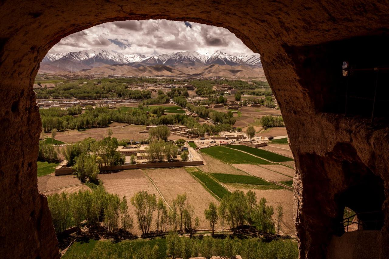 A view of snow-capped mountains and the lush green valley below where a Buddha statue stood in Bamiyan, Afghanistan, May 18, 2019. Since the Taliban destroyed the two giant statues in March 2001, the degradation has continued, as Afghanistan and the international community have spent 18 years debating what to do to protect or restore the site. (Jim Huylebroek/The New York Times)