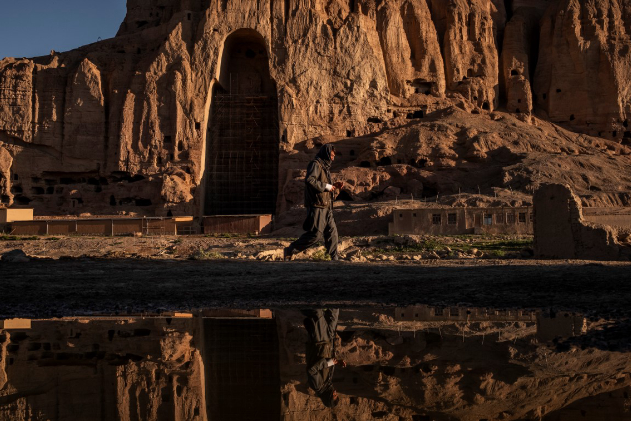 A laborer passes the western Buddha niche in Bamiyan, Afghanistan, May 20, 2019. Since the Taliban destroyed the two giant statues in March 2001, the degradation has continued, as Afghanistan and the international community have spent 18 years debating what to do to protect or restore the site. (Jim Huylebroek/The New York Times)