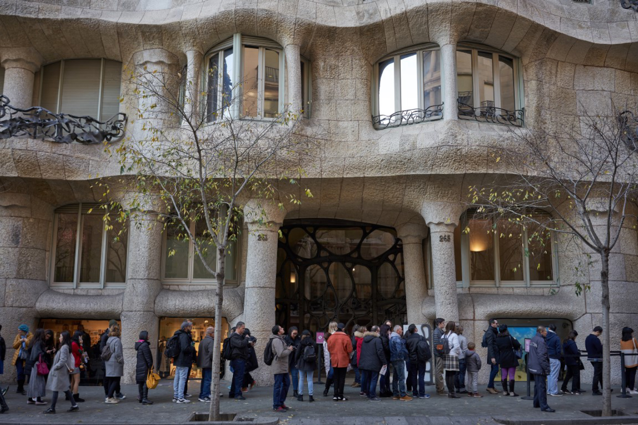 Tourists line up at the gate of the famous building of La Pedrera, designed by Catalan architect Antoni Gaudi, in Barcelona, Spain, Dec. 28, 2018. Living in Barcelona's most famous Gaudi home comes with its challenges. (Samuel Aranda/The New York Times)