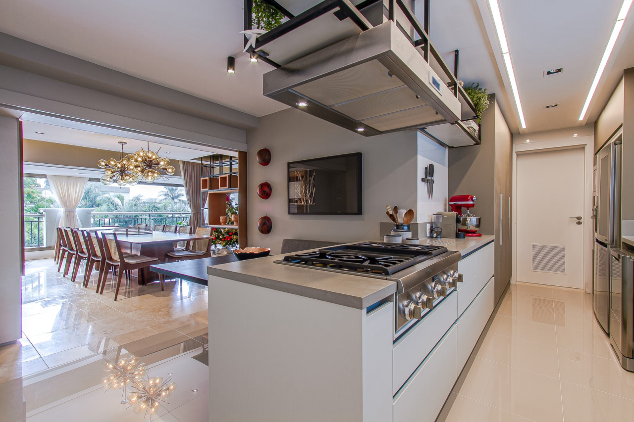 Cozinha é integrada ao restante das áreas comuns, mas pode ser isolada por meio de painéis instalados entre os cômodos. Foto: Francis Larsen / Divulgação