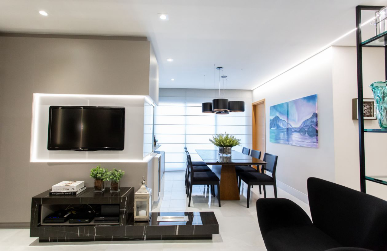 Painel da TV integra as alas de estar e jantar, se estendendo para um aparador com cristaleira. Foto: Mariana Maciel