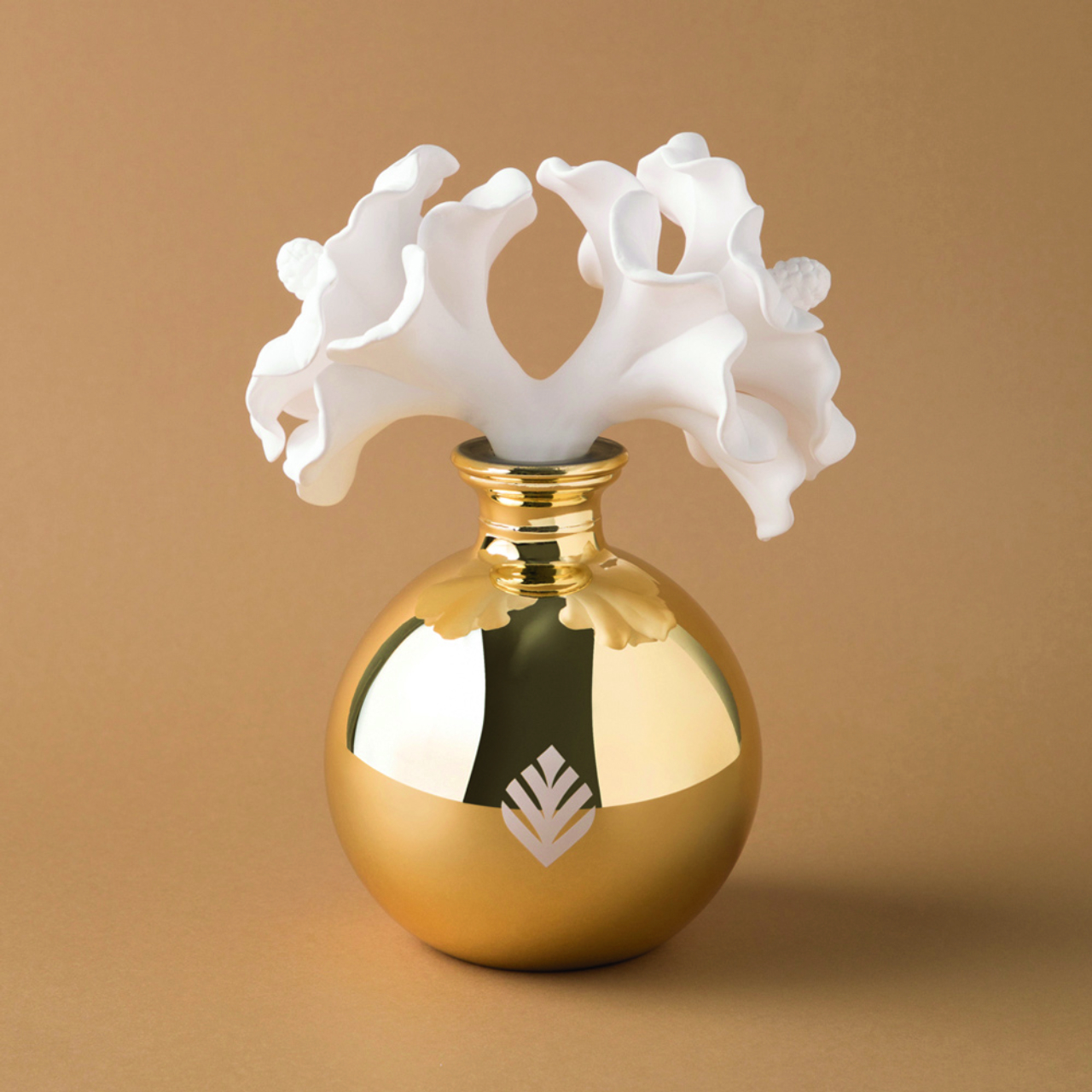Difusor de aromas<br>com frasco em vidro nas cores prata ou dourada e flores em porcelana.<br>Acompanha funil. R$ 490, na Tania Bulhões.
