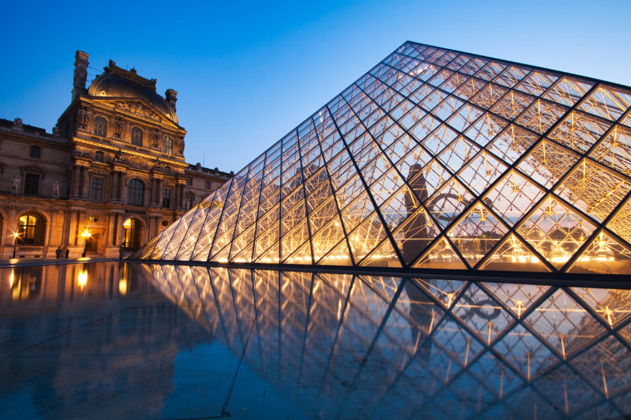 PARIS, FRANCE - JULY 6: The Louvre Pyramid at dusk during the Michelangelo Pistoletto Exhibition on July 6, 2013 in Paris. The Pyramid is the main entrance to the Louvre Museum. Completed in 1989 and became one of the landmarks of Paris