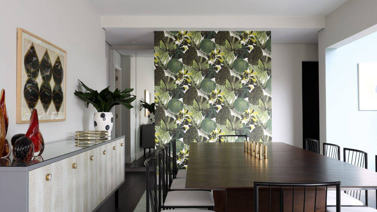 O ar tropicalista que complementa a pegada vintage da decoração está presente no papel de parede da sala de jantar, utilizado também nos nichos da cozinha