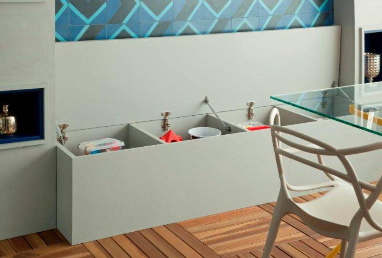). O banco abaixo dos ladrilhos hidráulicos é um suporte de mais lugares à mesa e de quebra guarda os brinquedos do filho do casal dono do apartamento