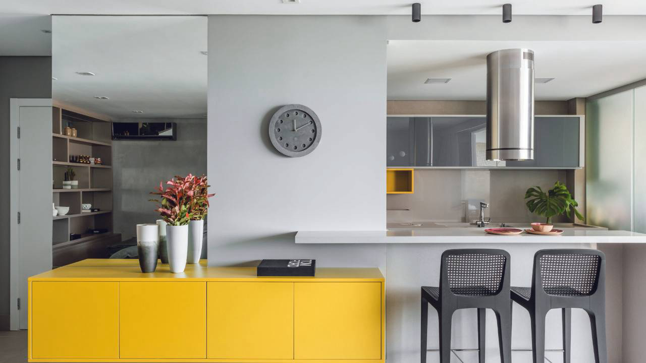  O amarelo se repete no mobiliário da sala e da cozinha, criando a sensação de integração pela cor.