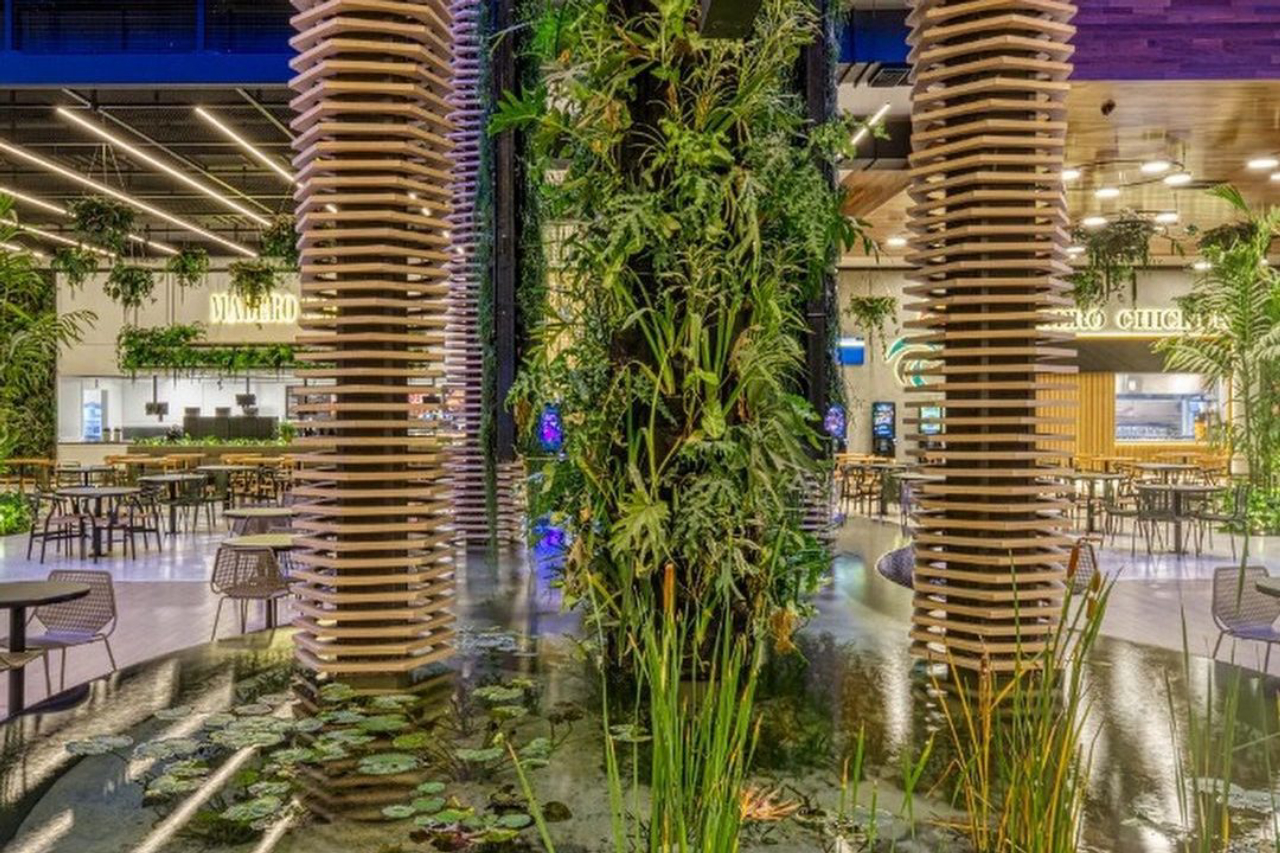 Detalhe do hall da EcoParada Madero, com jardim vertical e uma fonte.