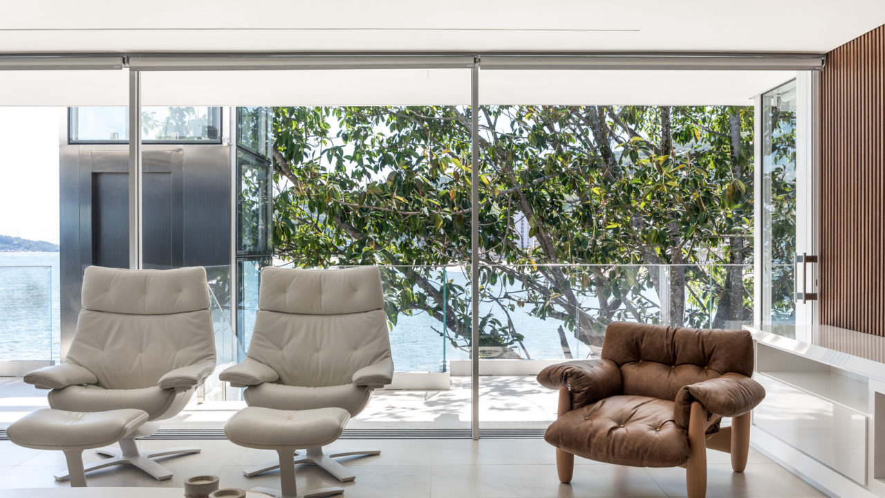 No interior, o estilo minimalista traz móveis em tons neutros, como a poltrona Mole, assinada por Sergio Rodrigues, da década de 1960.