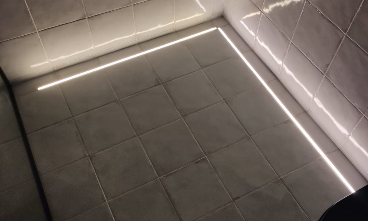 Detalhe dos fios de LED no piso do banheiro do Loft Deca, por Marcelo Lopes.