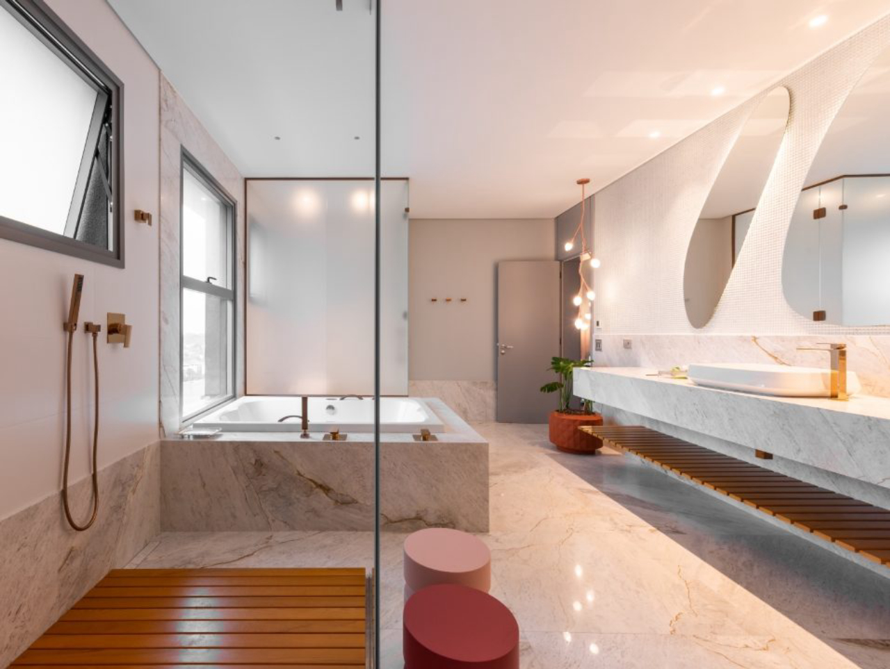 Formas orgânicas foram as escolhidas para destacar elementos da sala de banho, como espelhos e luminária.