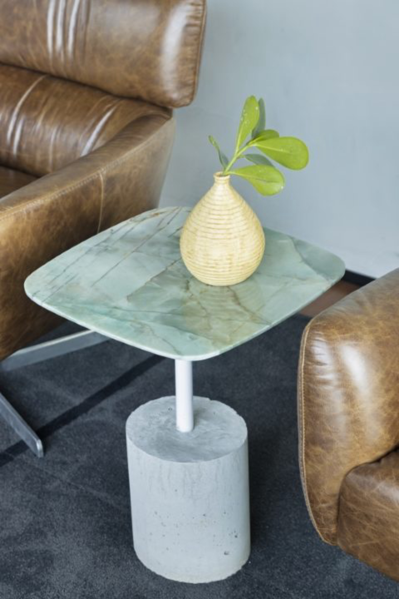 Projeto experimental da arquiteta, mesa lateral tem base em cimento e fibra de coco e tampo de cristal verde de MG. 