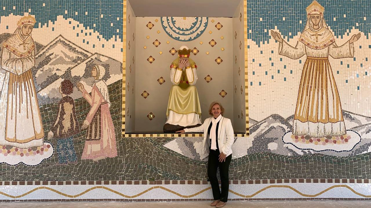 A artista Mari Bueno em frente ao mosaico finalizado