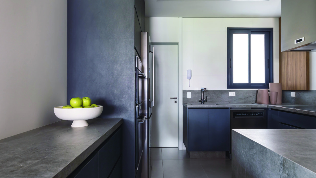 A cozinha parcialmente integrada permite um uso independente dos ambientes e mantém a sensação de amplitude da área social.