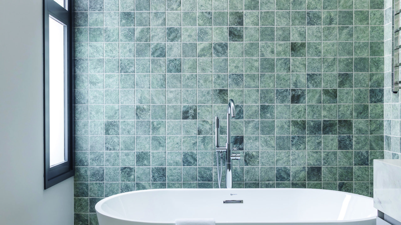 No banheiro, a escolha da pedra e do azulejo colaboram com a sensação de relaxamento.