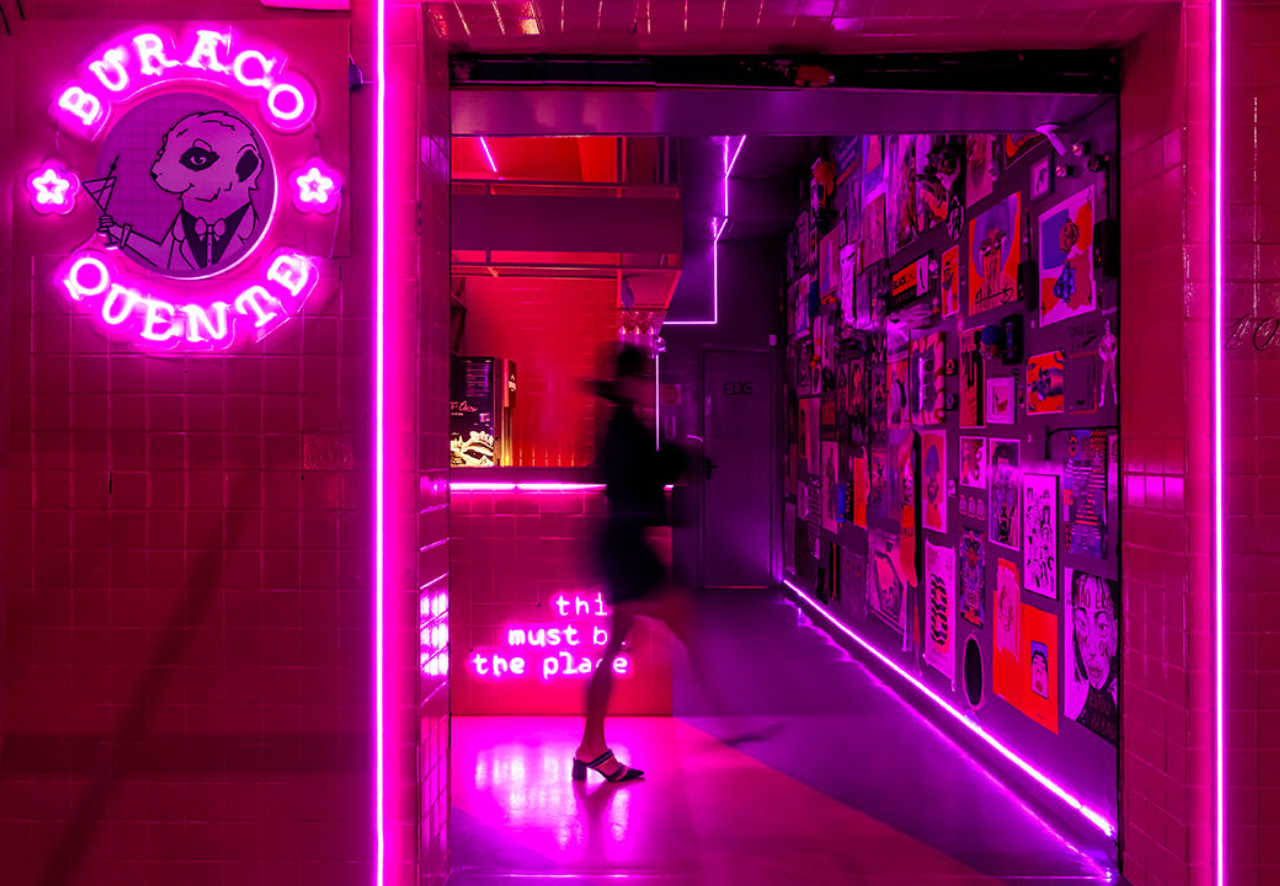 As duas cores do projeto – rosa e roxo –&nbsp;dão unidade às áreas interna e externa do bar, como na aplicação no piso, que guia o cliente